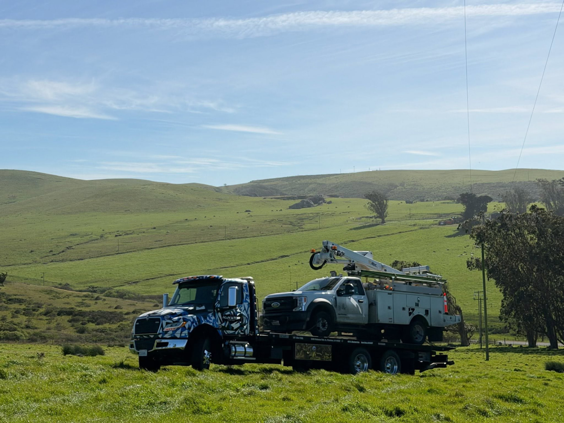 Non Stop Towing flatbed rollback carrying a utility truck in Sonoma County