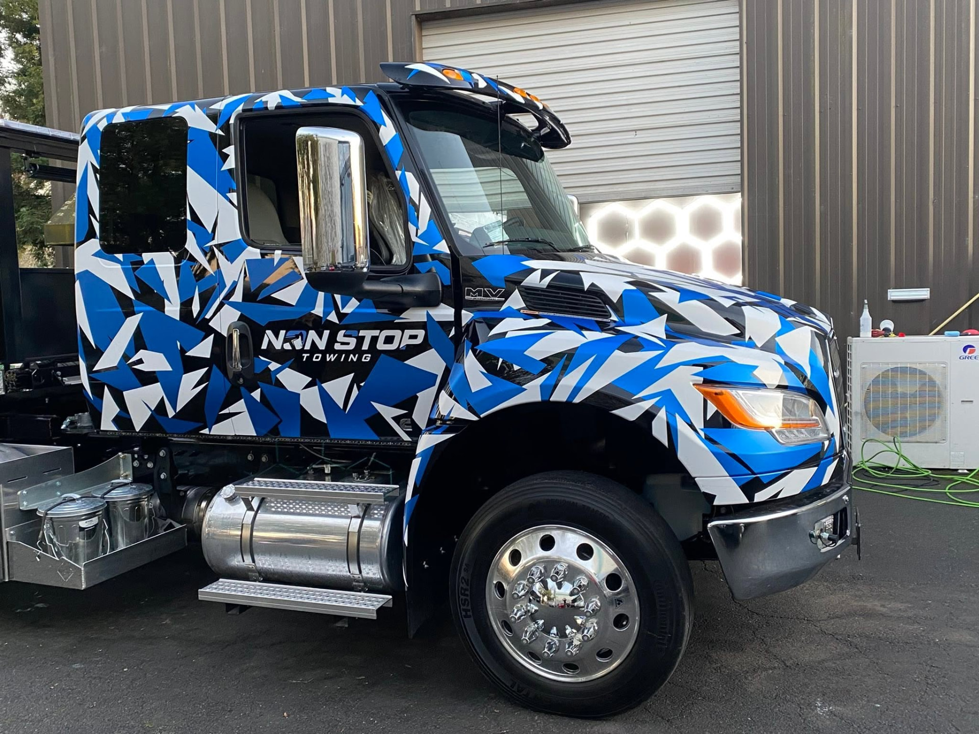 Non Stop Towing camo-wrapped heavy duty wrecker